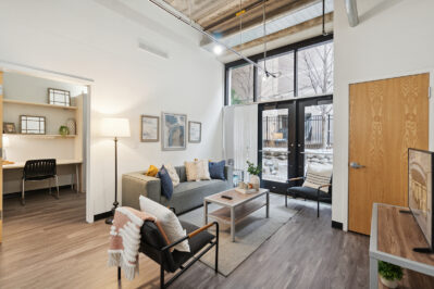 Furnished living space with a TV and large windows