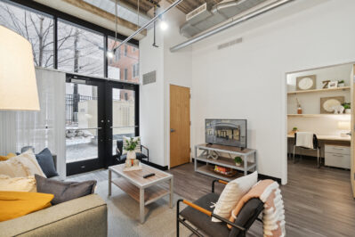 Furnished living space with a TV and large windows
