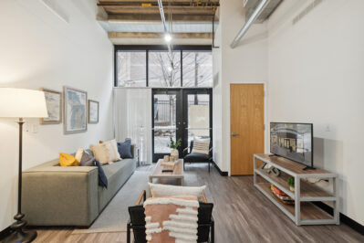 Furnished living space with a TV and large windows